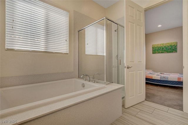 bathroom featuring a stall shower, ensuite bathroom, and a garden tub