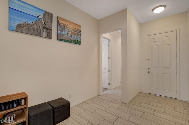 foyer featuring baseboards and wood finish floors