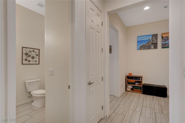 hallway featuring visible vents and baseboards