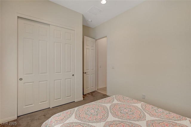 carpeted bedroom featuring a closet, baseboards, and visible vents