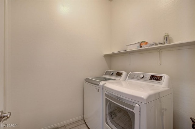 clothes washing area featuring washer and dryer, baseboards, and laundry area