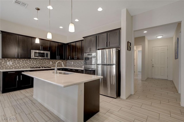 kitchen with visible vents, a sink, tasteful backsplash, appliances with stainless steel finishes, and light countertops