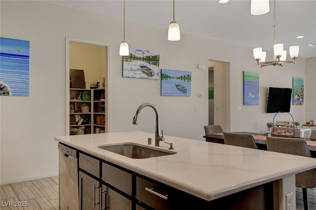 kitchen with a notable chandelier, a kitchen island with sink, a sink, light countertops, and dishwasher