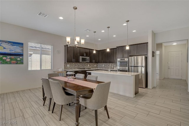 dining room featuring an inviting chandelier, recessed lighting, and visible vents