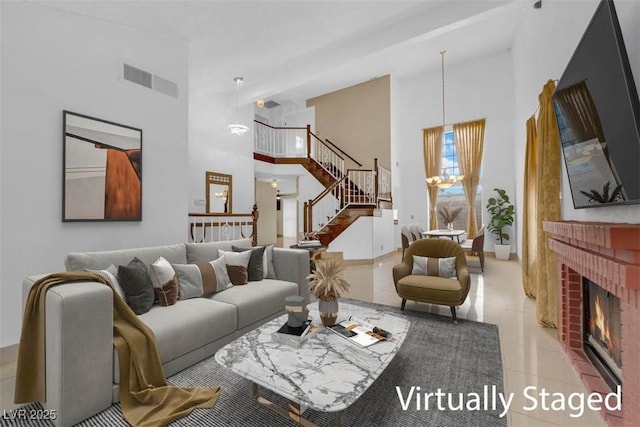 tiled living area with visible vents, a high ceiling, a fireplace, and stairs