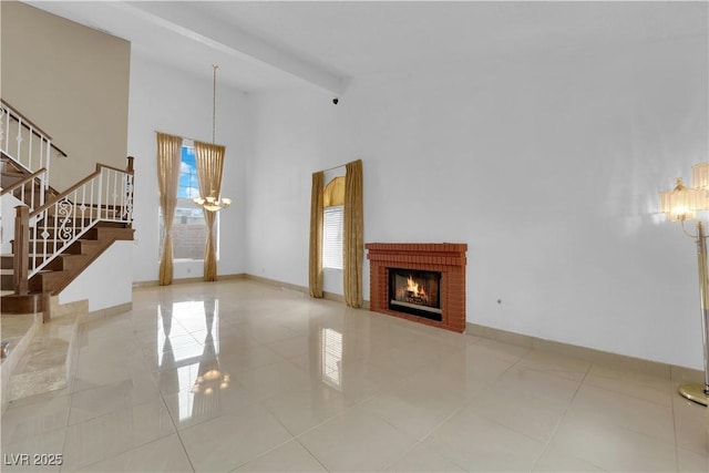 unfurnished living room featuring baseboards, beamed ceiling, stairs, a fireplace, and high vaulted ceiling