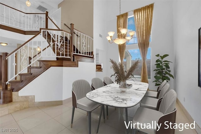 tiled dining area with a chandelier, baseboards, a towering ceiling, and stairs