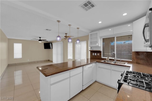 kitchen featuring visible vents, ceiling fan, dishwasher, a peninsula, and a sink