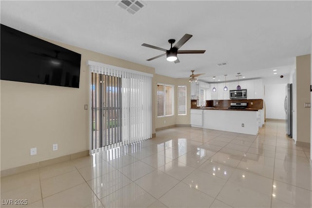 unfurnished living room featuring light tile patterned floors, visible vents, baseboards, and ceiling fan