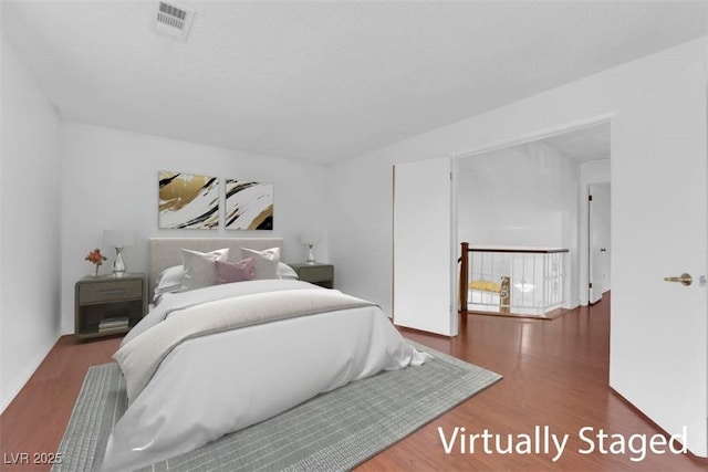 bedroom with wood finished floors and visible vents