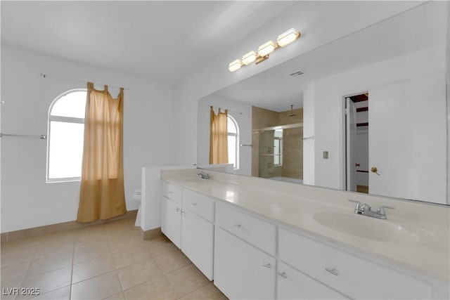 full bathroom featuring a wealth of natural light, a stall shower, and a sink