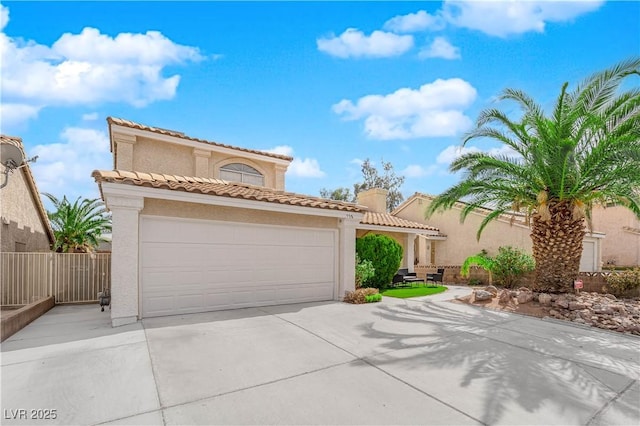 mediterranean / spanish house with a garage, a tile roof, concrete driveway, and stucco siding