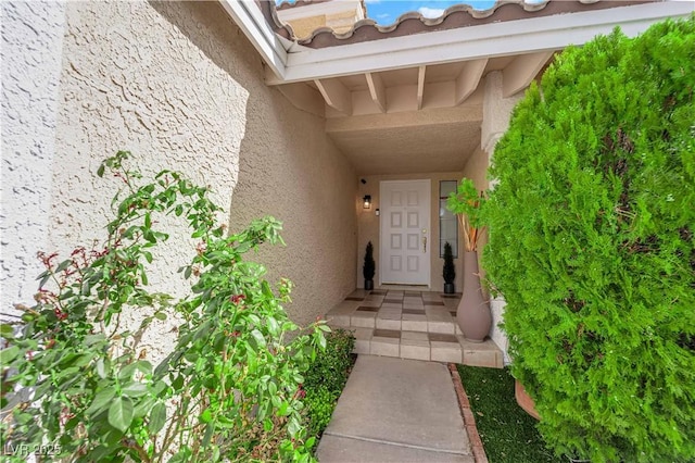 doorway to property featuring stucco siding