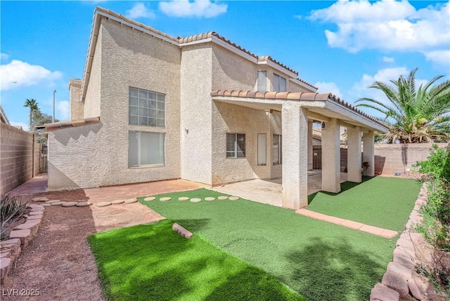 back of property with stucco siding, a patio, a fenced backyard, and a tile roof