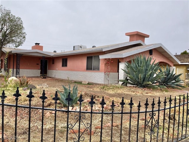 view of front facade with brick siding and fence