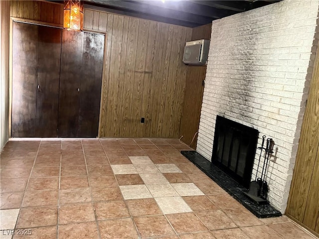 basement featuring an AC wall unit, a brick fireplace, and wood walls