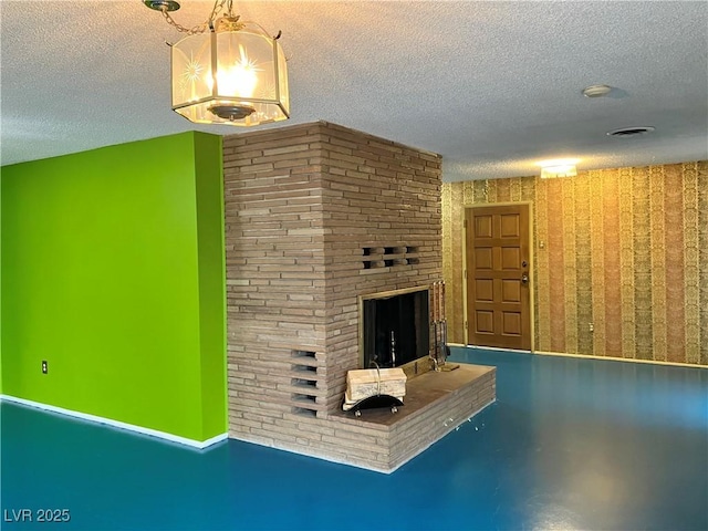 unfurnished living room featuring finished concrete flooring, a fireplace, visible vents, and a textured ceiling