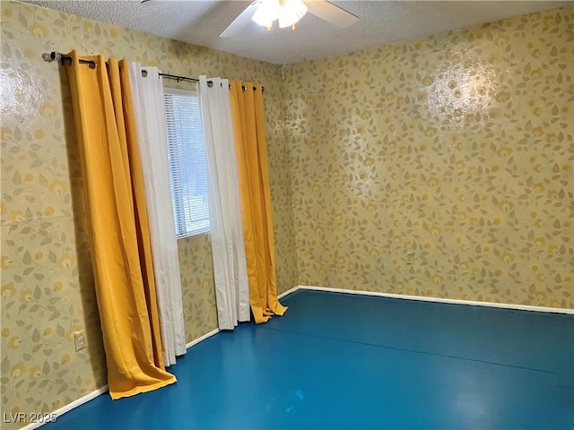 unfurnished room with a textured ceiling, a ceiling fan, and wallpapered walls