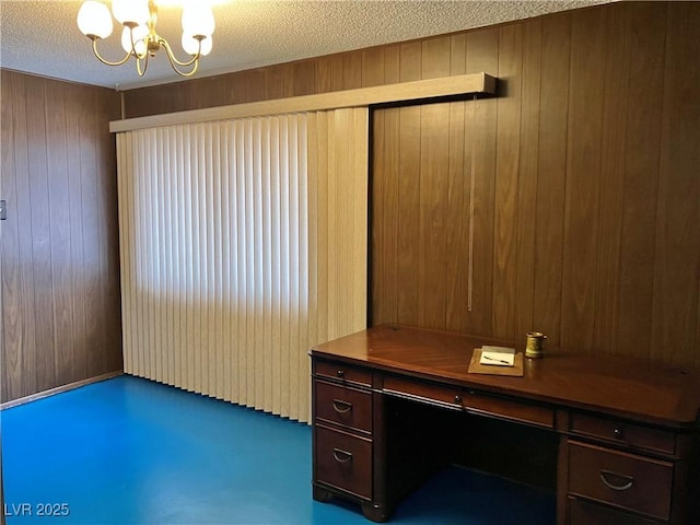 unfurnished office featuring a textured ceiling, an inviting chandelier, and wooden walls