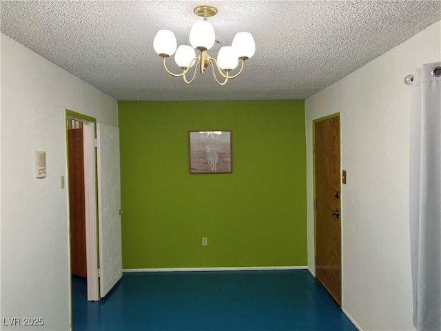 empty room with a textured ceiling and a chandelier