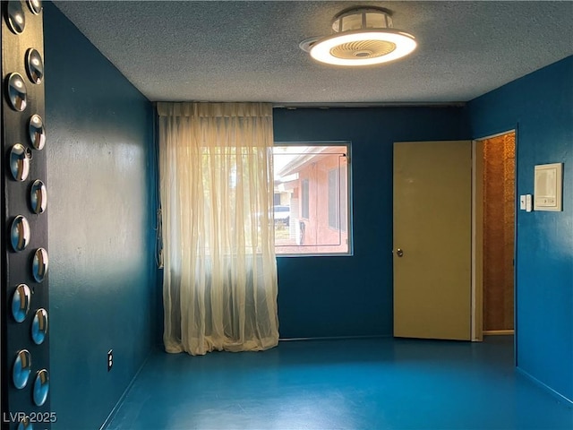 spare room with finished concrete flooring and a textured ceiling