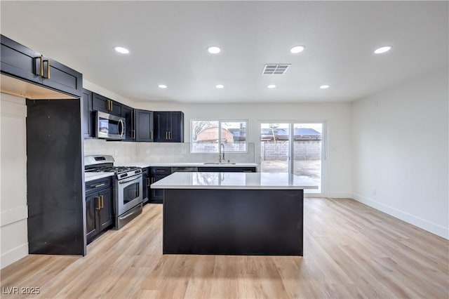 kitchen with visible vents, light countertops, light wood-style flooring, appliances with stainless steel finishes, and a sink