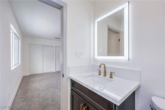 bathroom with vanity, toilet, and baseboards