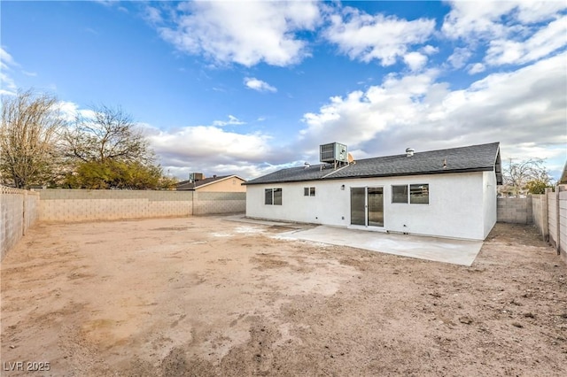 rear view of property with stucco siding, a patio, central AC unit, and a fenced backyard