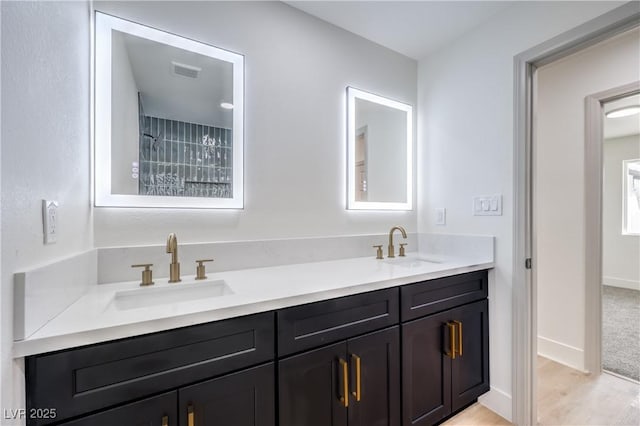 bathroom with a sink, visible vents, baseboards, and double vanity