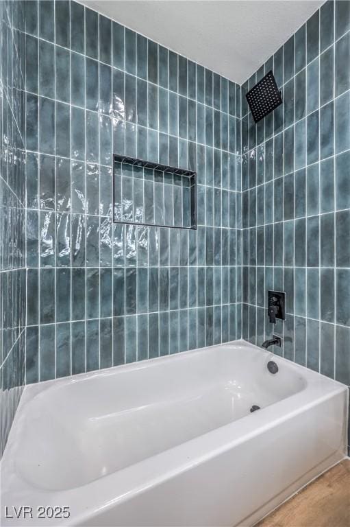 bathroom featuring tile walls, shower / bathtub combination, and wood finished floors