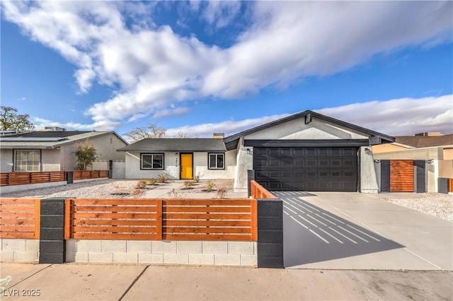 view of front of house featuring a fenced front yard, stucco siding, driveway, and a garage