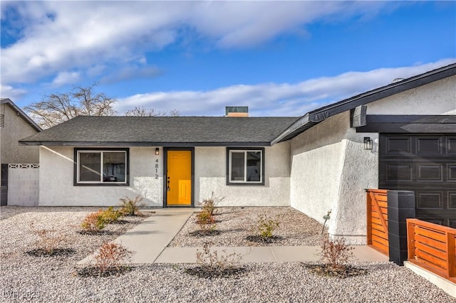 view of front of property featuring stucco siding, roof with shingles, and fence