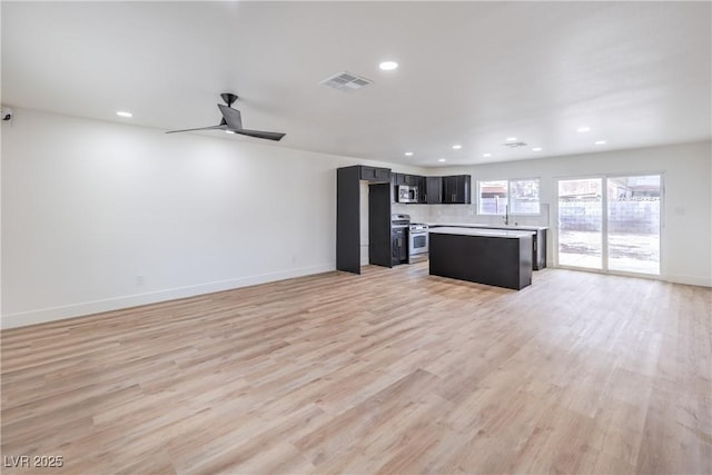 kitchen featuring visible vents, open floor plan, light countertops, light wood-style floors, and stainless steel appliances