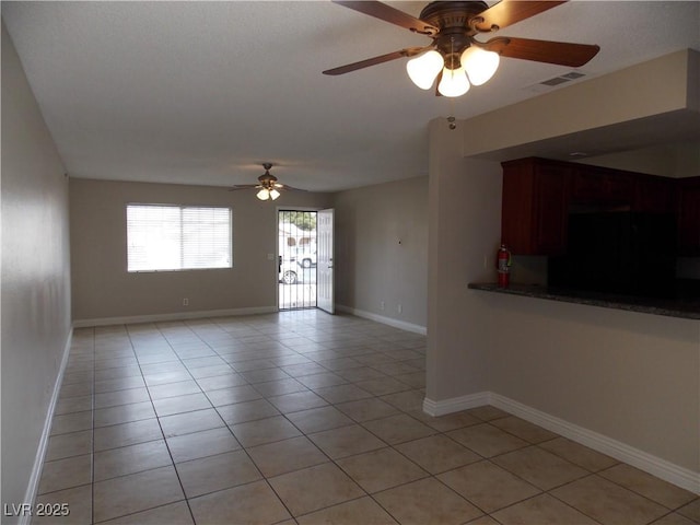 unfurnished living room with light tile patterned flooring, visible vents, baseboards, and a ceiling fan