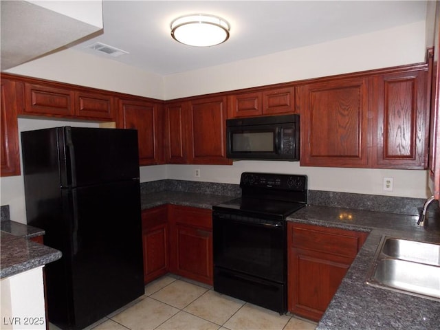 kitchen featuring light tile patterned flooring, visible vents, black appliances, and a sink