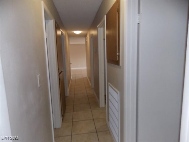 hallway with light tile patterned floors and baseboards