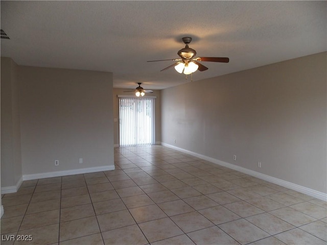 spare room featuring light tile patterned floors, a ceiling fan, baseboards, and a textured ceiling