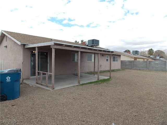 rear view of house featuring stucco siding, a patio, central AC, and a fenced backyard