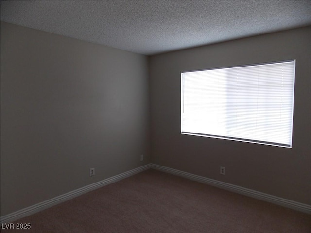 unfurnished room with a textured ceiling, baseboards, and carpet floors