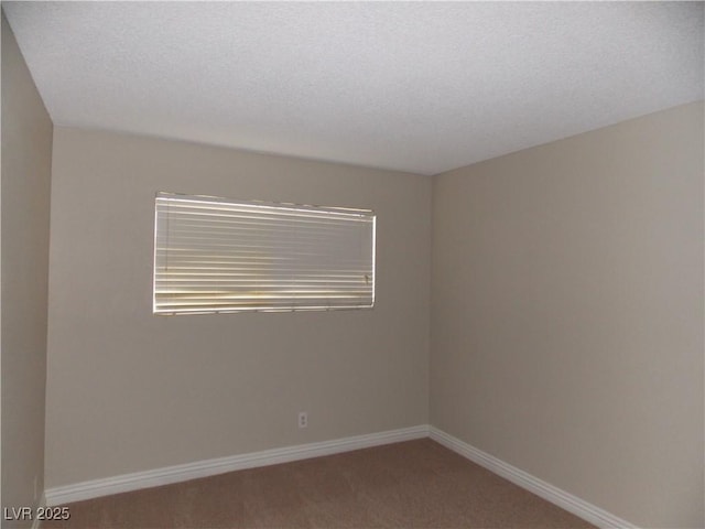 spare room with baseboards, carpet floors, and a textured ceiling