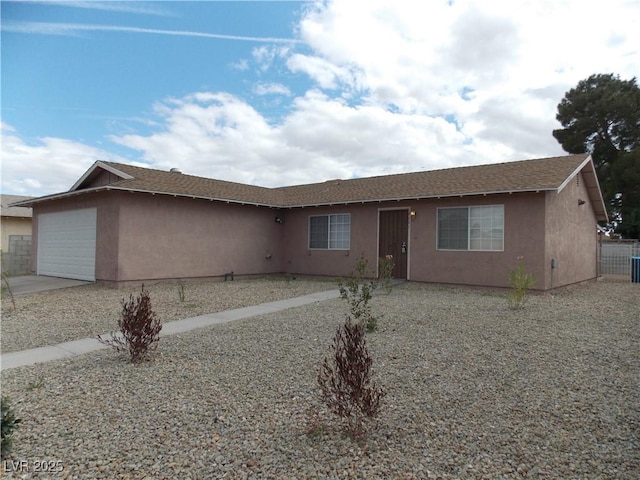 single story home featuring a garage, concrete driveway, and stucco siding