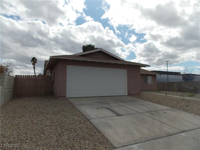 garage with driveway and fence