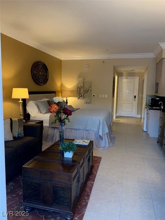 bedroom with light tile patterned flooring and crown molding