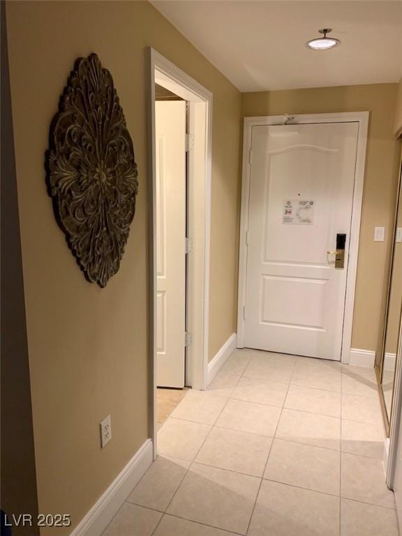 corridor with light tile patterned flooring, recessed lighting, and baseboards