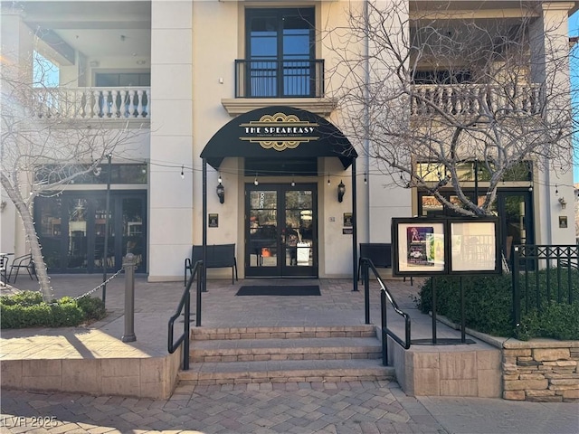 view of exterior entry with stucco siding and french doors