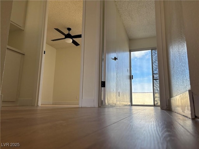 unfurnished room with ceiling fan, baseboards, and a textured ceiling