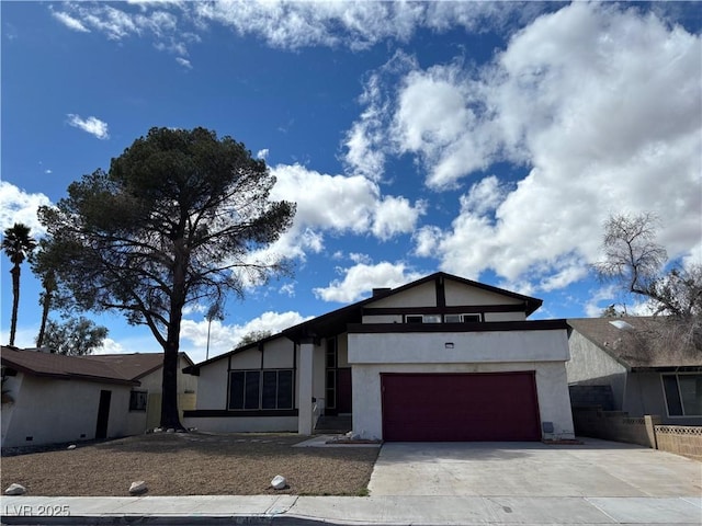 view of front of house with stucco siding, driveway, and an attached garage