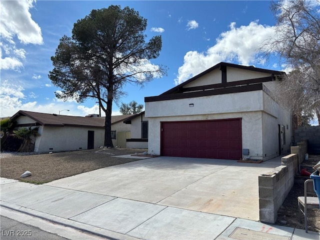 view of front of home with concrete driveway, a garage, and stucco siding