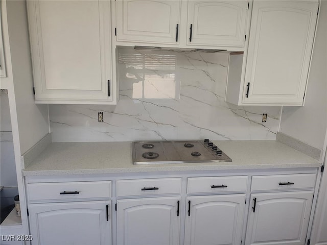 kitchen with decorative backsplash, light countertops, and stainless steel stovetop