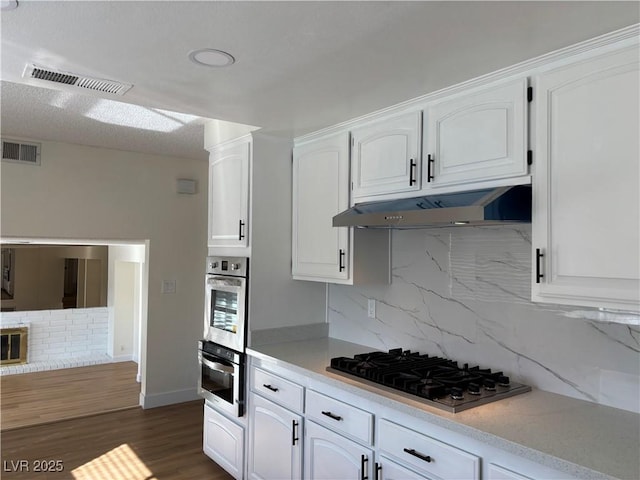 kitchen featuring white cabinetry, appliances with stainless steel finishes, visible vents, and under cabinet range hood